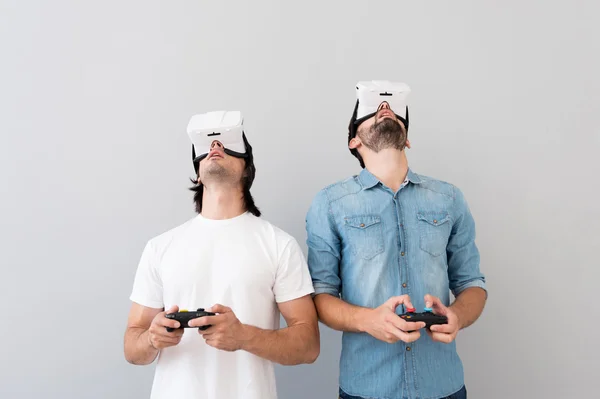 Homens agradáveis usando óculos de realidade virtual — Fotografia de Stock
