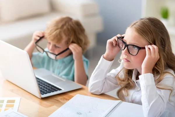 Niño y niña poniéndose gafas — Foto de Stock