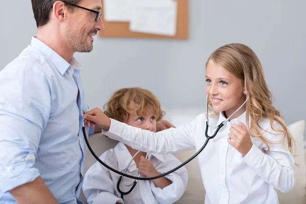 Niña satisfecha escuchando latidos del corazón — Foto de Stock