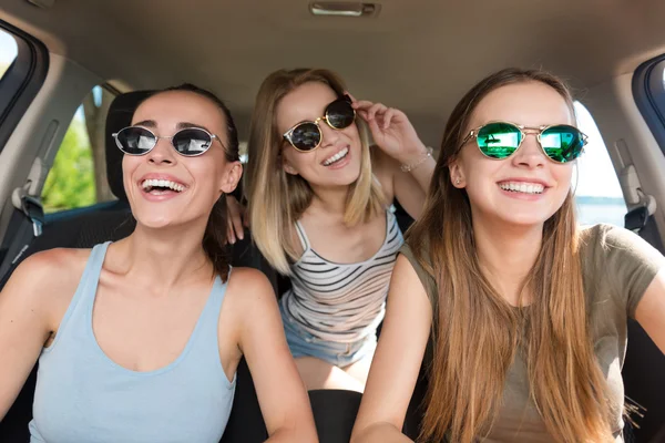 Amigos sorridentes positivos dirigindo um carro — Fotografia de Stock