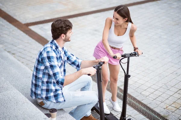 Amigos alegres usando scooters — Fotografia de Stock
