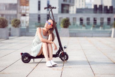 Gülümseyen kadın bir tekme scooter sürme