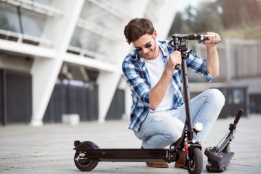 Keyifli adam tekme scooter tutan