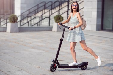 Neşeli kadın bir tekme scooter sürme