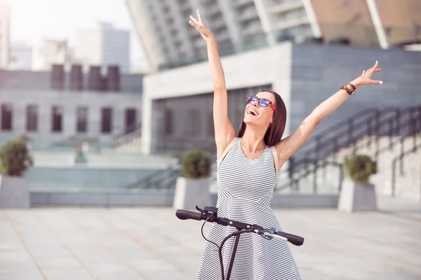 Mujer alegre montando patinete scooter — Foto de Stock