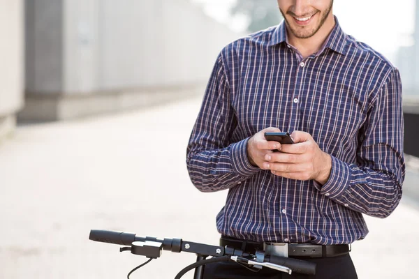 Homme souriant utilisant un téléphone portable — Photo