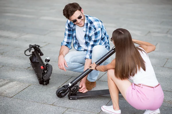 Lachende vrienden houden kick scooters — Stockfoto