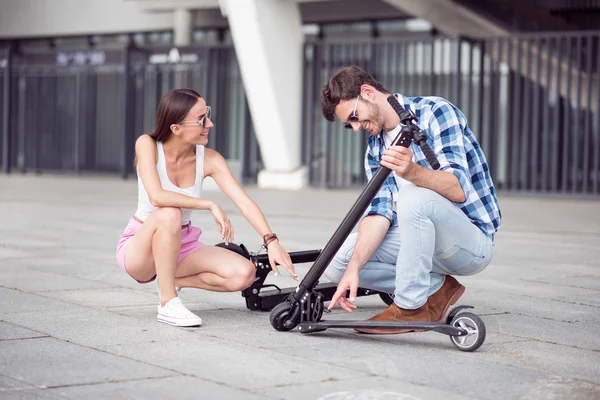 Amigos alegres usando patinetes scooters —  Fotos de Stock