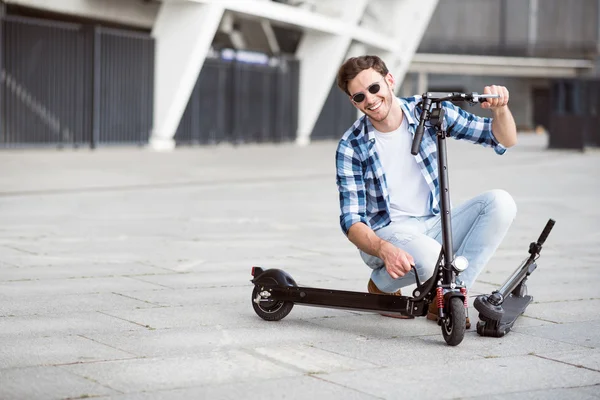 Positivo uomo in possesso di calcio scooter — Foto Stock