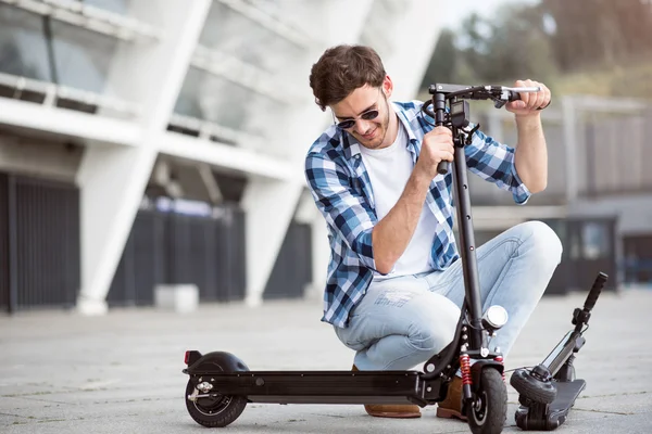 Homem agradável segurando scooter pontapé — Fotografia de Stock