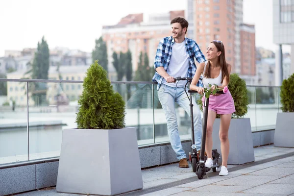 Amici positivi equitazione calci scooter — Foto Stock