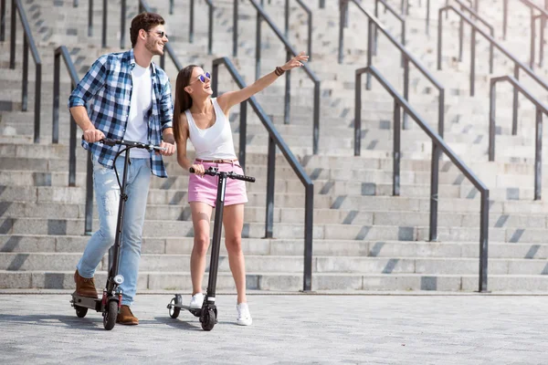 Amici allegri utilizzando scooter — Foto Stock