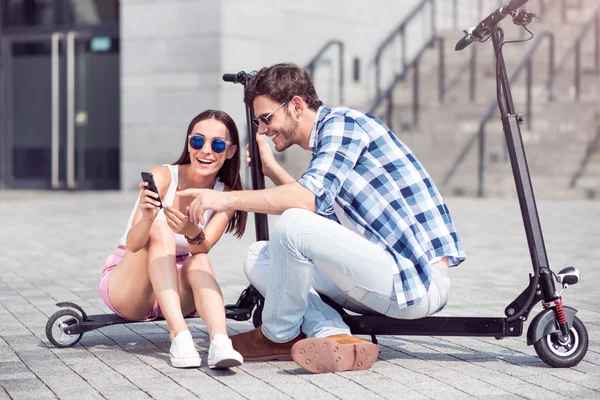 Amici sorridenti seduti sugli scooter — Foto Stock