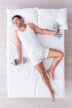Handsome young man sleeping on bed clipart