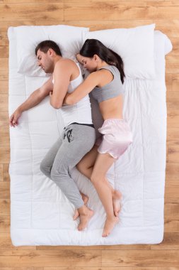 Genç çift yatakta uyuyor.