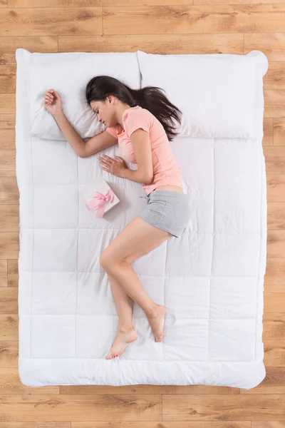 Wanita muda positif tidur di tempat tidur — Stok Foto