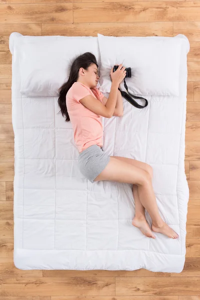 Wanita muda positif tidur di tempat tidur — Stok Foto