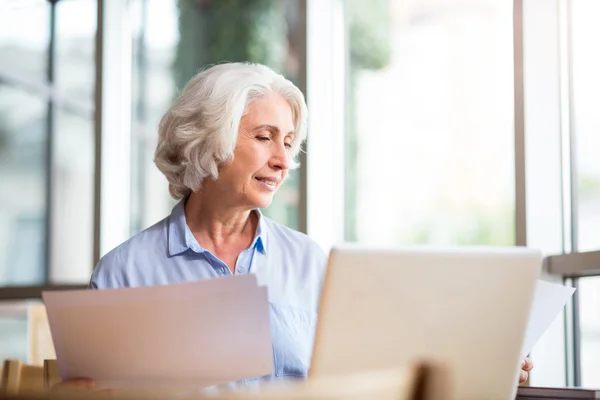 Pleasant content aged woman sitting in the cafe — Stock Photo, Image