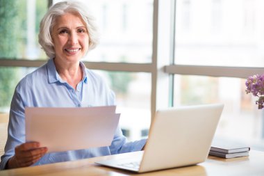 Masada oturan neşeli üst düzey kadın