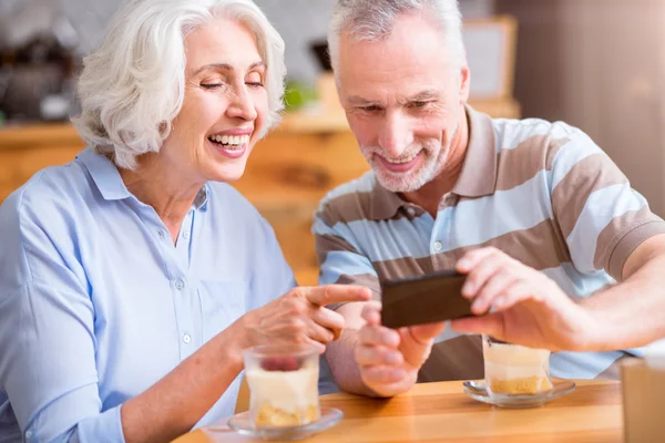 Cheerful senior couple sitting in the cafe — Stock Photo, Image