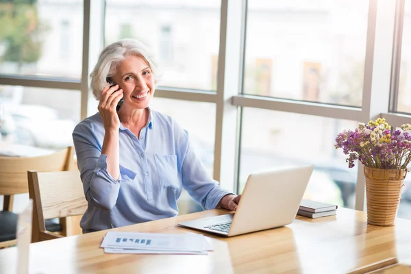 O femeie în vârstă veselă vorbind pe telefonul mobil — Fotografie, imagine de stoc