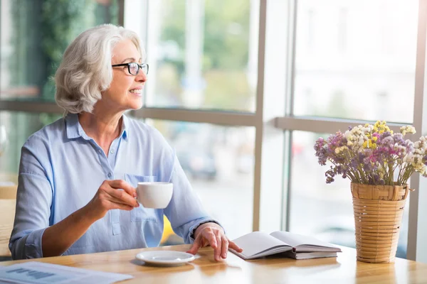 Donna anziana allegra seduta nel caffè — Foto Stock