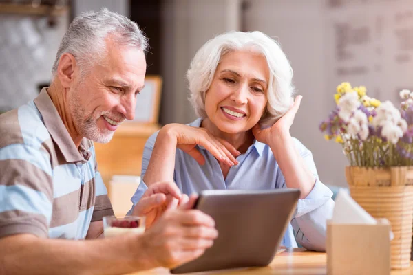 Alegre pareja sonriente descansando en la mesa — Foto de Stock