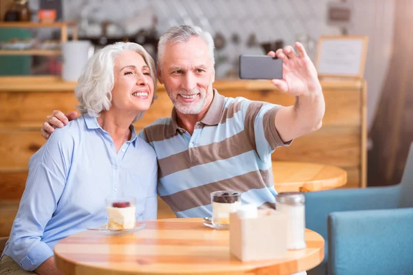 Casal sênior positivo descansando no café — Fotografia de Stock