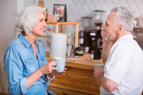 Позитивная пожилая пара пьет кофе — стоковое фото