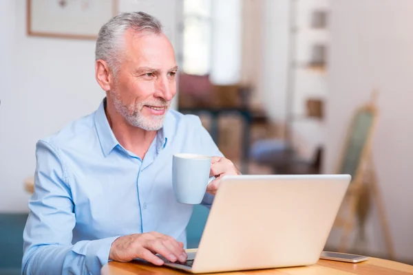 Fröhlicher Mann sitzt am Tisch — Stockfoto