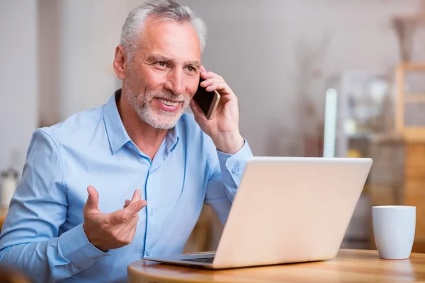 Pozitivní starší muž mluví do mobilního telefonu — Stock fotografie