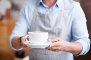 Sıcak bir içecek tutan bir adam