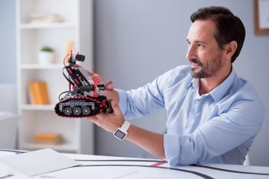 Onun robot buluşu gözlemleyerek mutlu bilim adamı