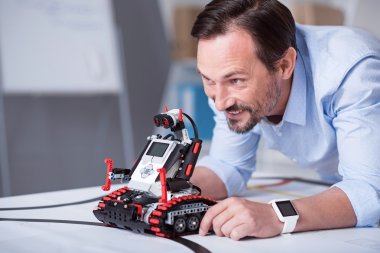 Orta yaşlı çekici adamın bir robot başlatılması
