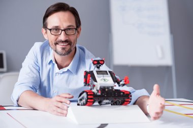 Yakışıklı adam ile küçük bir kırmızı robot poz