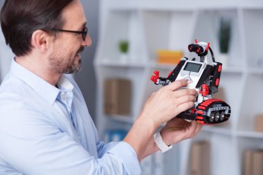 Heyecanlı yaşlı adam küçük droid çalışmalarını çalışıyor