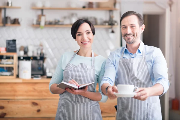 Due camerieri in grembiuli in piedi nel caffè — Foto Stock