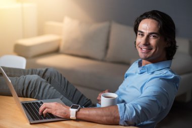 Gülümseyen eğlenceli yang adam çay içme .