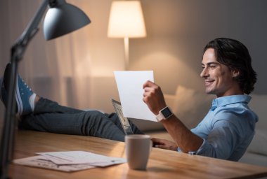 Gülümseyen iyi görünümlü yang adam bir belge gözlemleyerek .