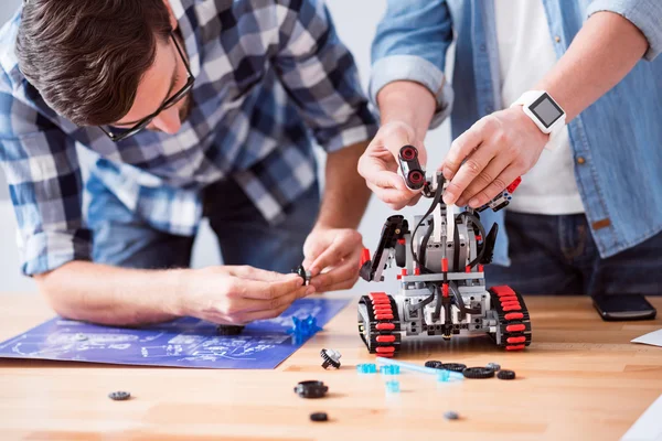 Piacevoli colleghi che costruiscono robot — Foto Stock