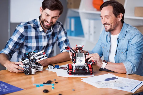 Радостные коллеги тестируют роботов — стоковое фото