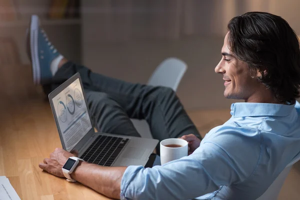 Sorrindo satisfeito yang homem trabalhando no laptop  . — Fotografia de Stock