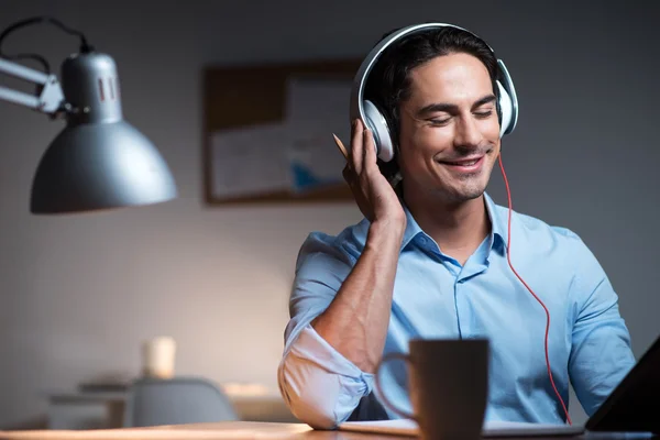 Fröhlicher junger Mann hört Musik — Stockfoto