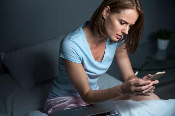Concerned woman sitting in bed — Stock Photo, Image