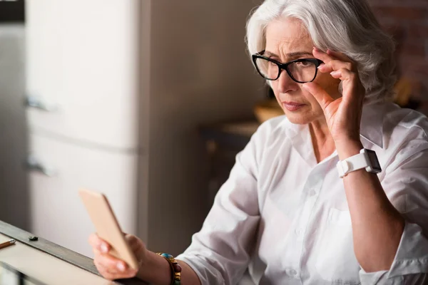 Old lady is being worried receiving new message on her phone — Stock Photo, Image