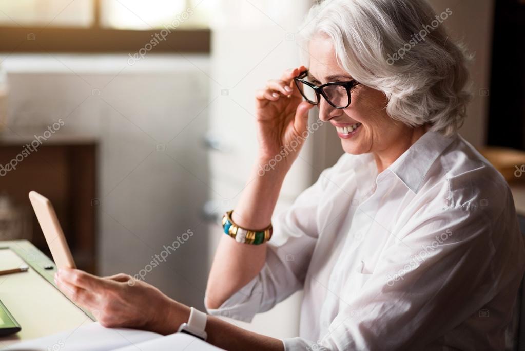 Senious caucasian lady checking her cell-phone