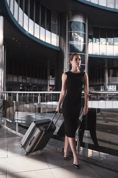 Geschäftsfrau mit Koffer läuft im Flughafen — Stockfoto