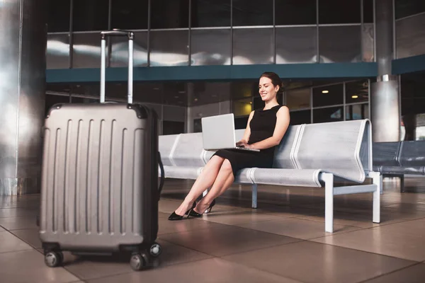 Frau benutzt ihren Computer am Flughafen — Stockfoto