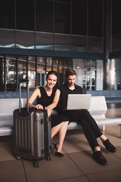 Hombre y mujer esperando un vuelo juntos — Foto de Stock