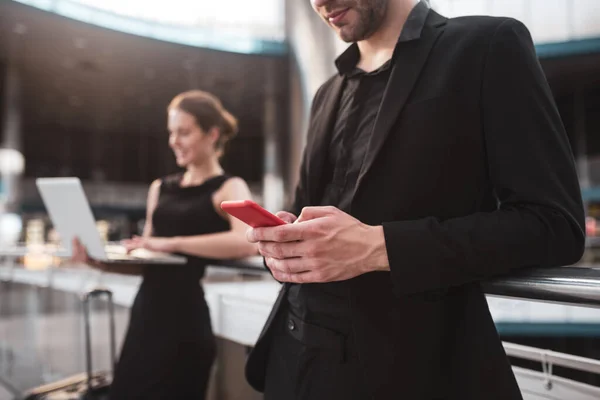 Hombre oficialmente vestido escribiendo un mensaje en un teléfono inteligente — Foto de Stock